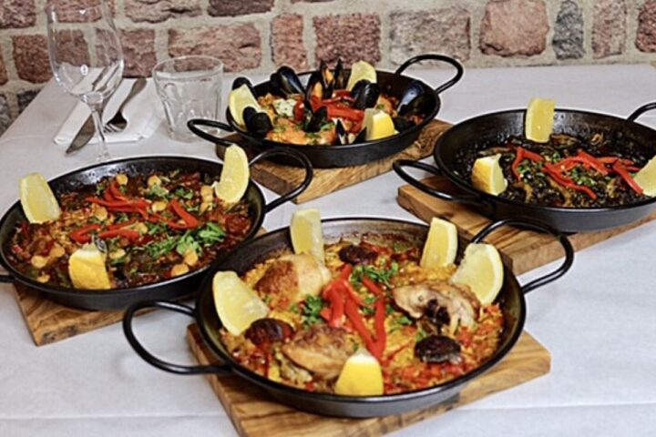 Four paella dishes on table 