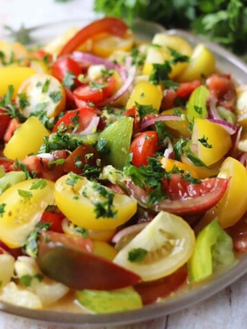 Tomato salad with gremolata on glass plate