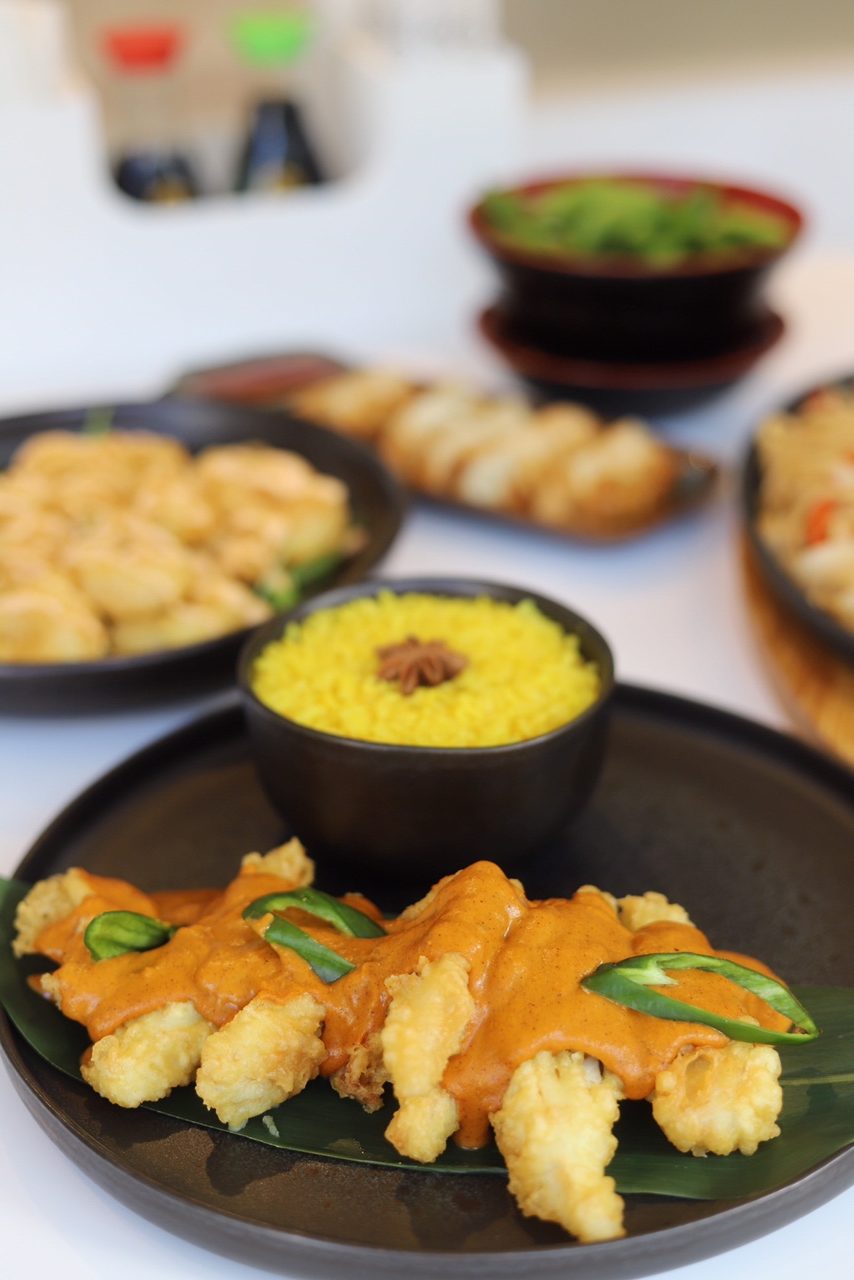 samll dishes of starters and plate of cod curry and rice