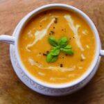 overview of soup with basil garnish in white bowl