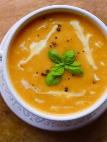 overview of soup with basil garnish in white bowl