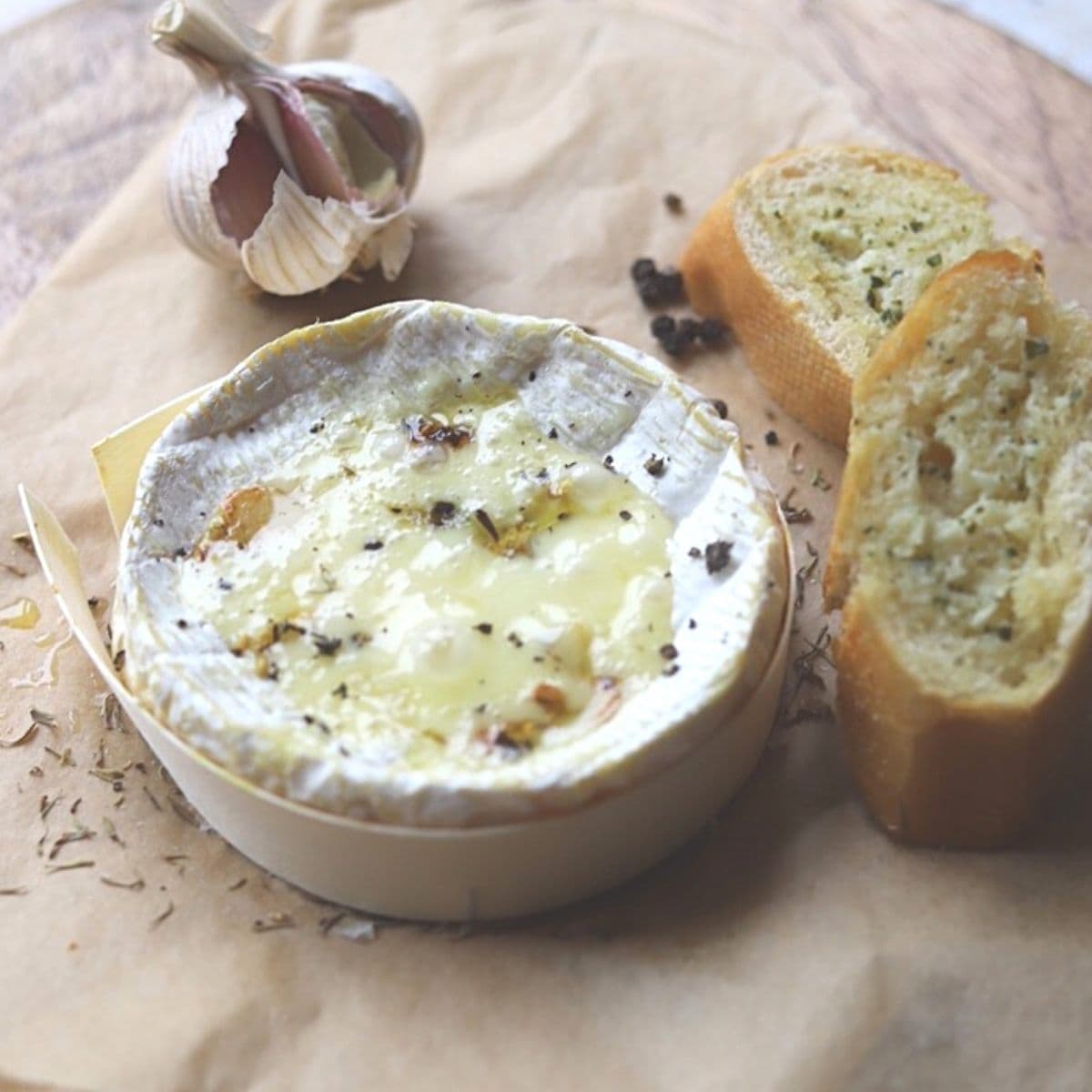 Baked camembert on parchment paper with garlic bread