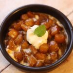 caramelized apples in black bowl with crème fraîche