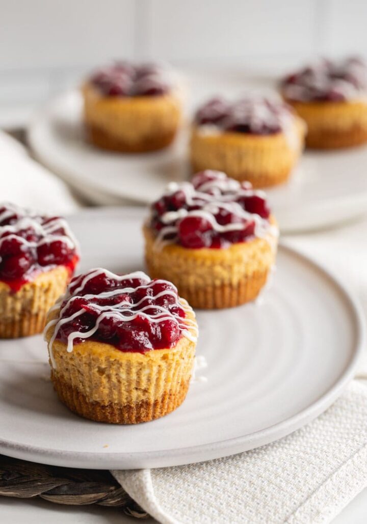 small cheesecakes topped with cranberry sauce on plates