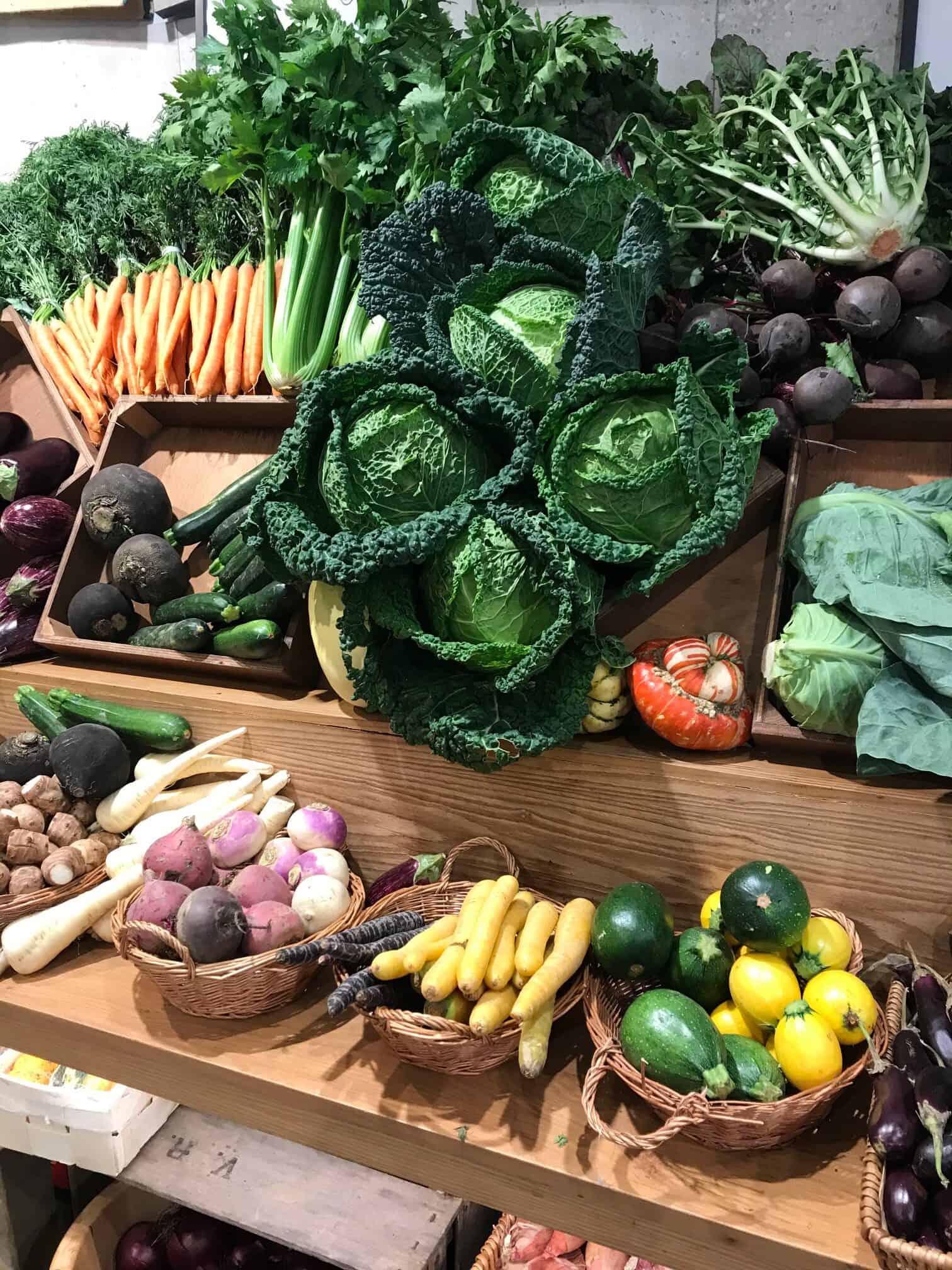 Fresh produce on display on shelves in a shop.