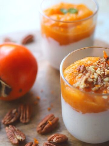 closeup of two glasses with persimmon and ricotta