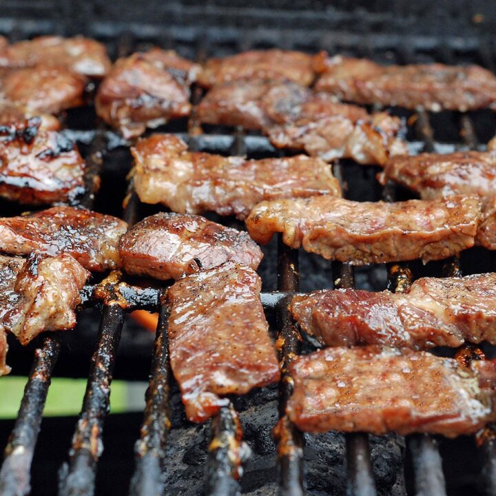 Image of jerked beef cooking on a grill.