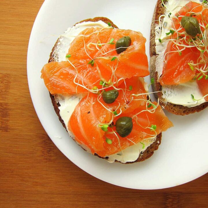 Image of salmon on slices of brown bread with cream cheese and capers.