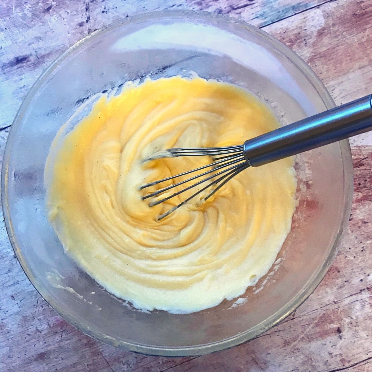custard in cold glass bowl with whisk