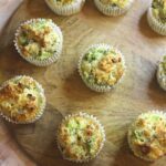 Image of broccoli cheese muffins on wooden board.