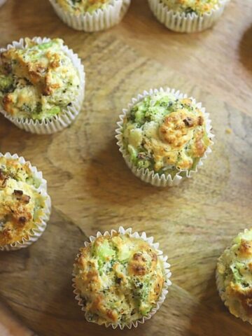 Image of broccoli cheese muffins on wooden board.
