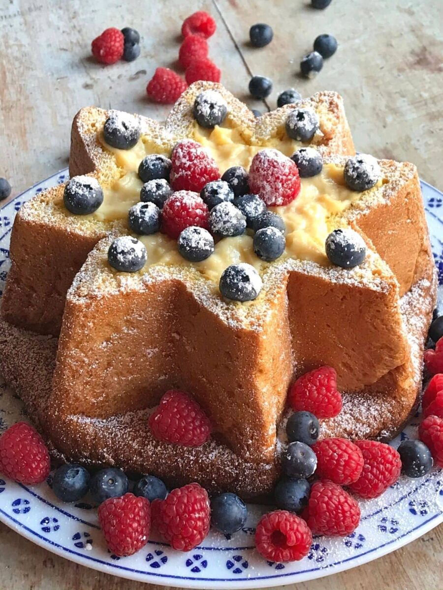 horizontal slice of pandoro filled with custard and berries