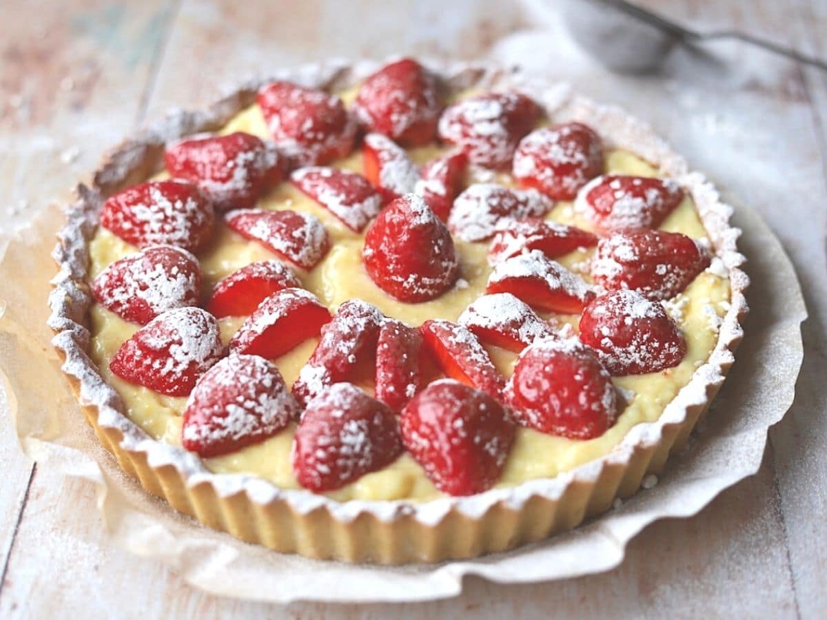 Strawberry tart with sliced strawberries and dusting of powdered sugar.