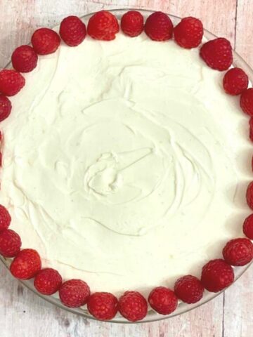 Image of lemon cheesecake decorated with raspberries.