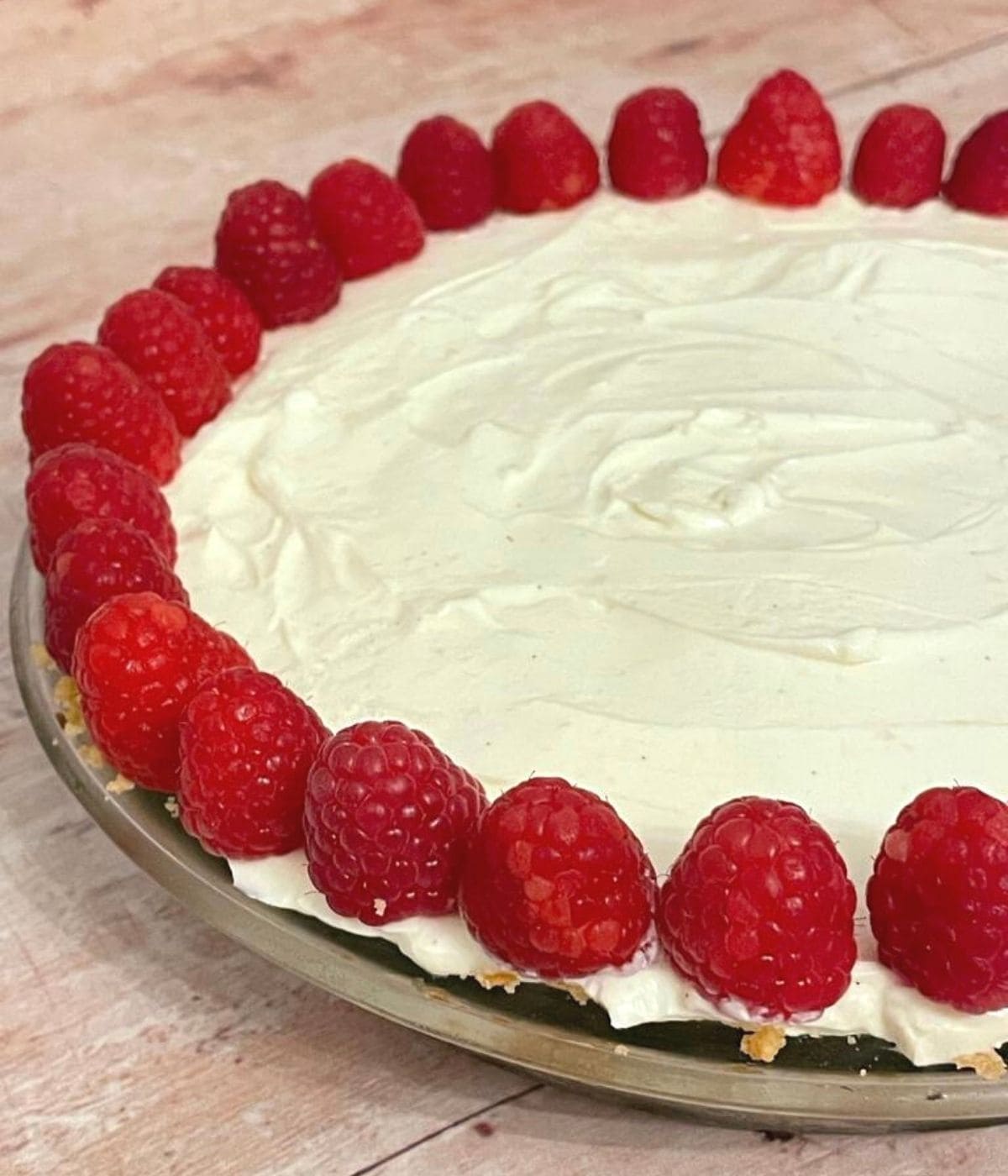 side view of cheesecake with raspberries