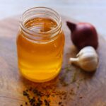 Image of yellow niter kibbeh in a glass jar.