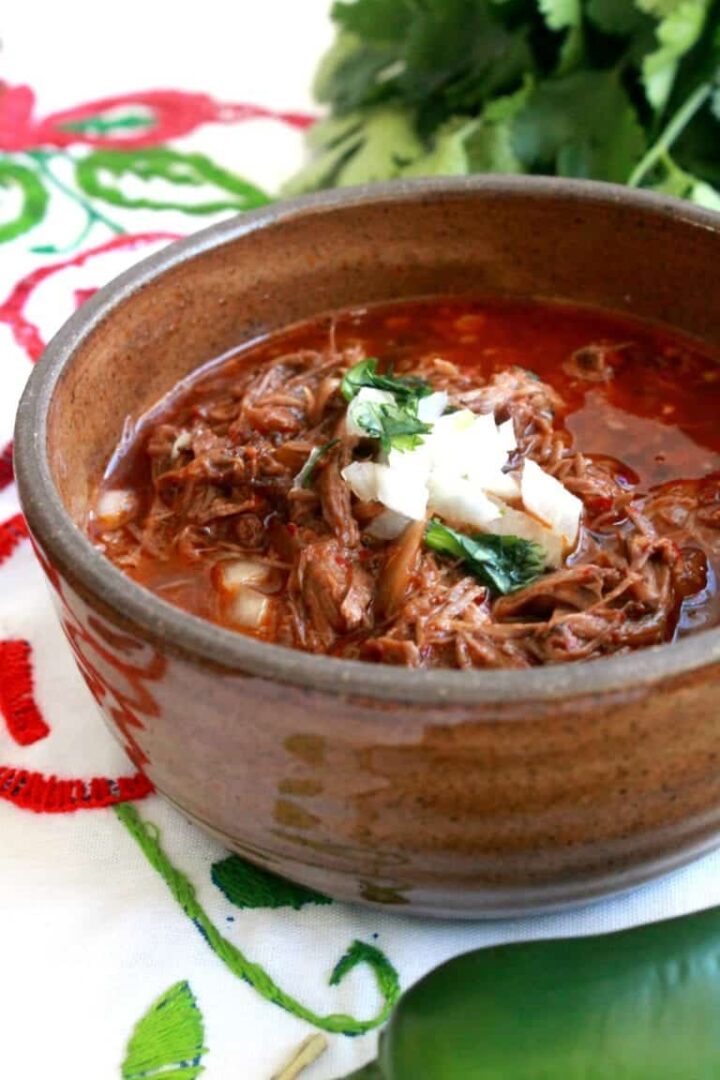 Image of a large brown bowl of birria de res.