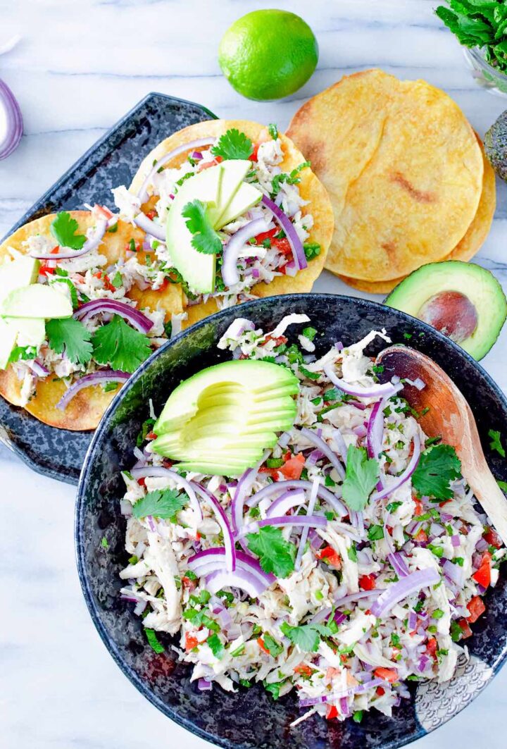 Image of chicken salad in large bowl and served on two tortillas.