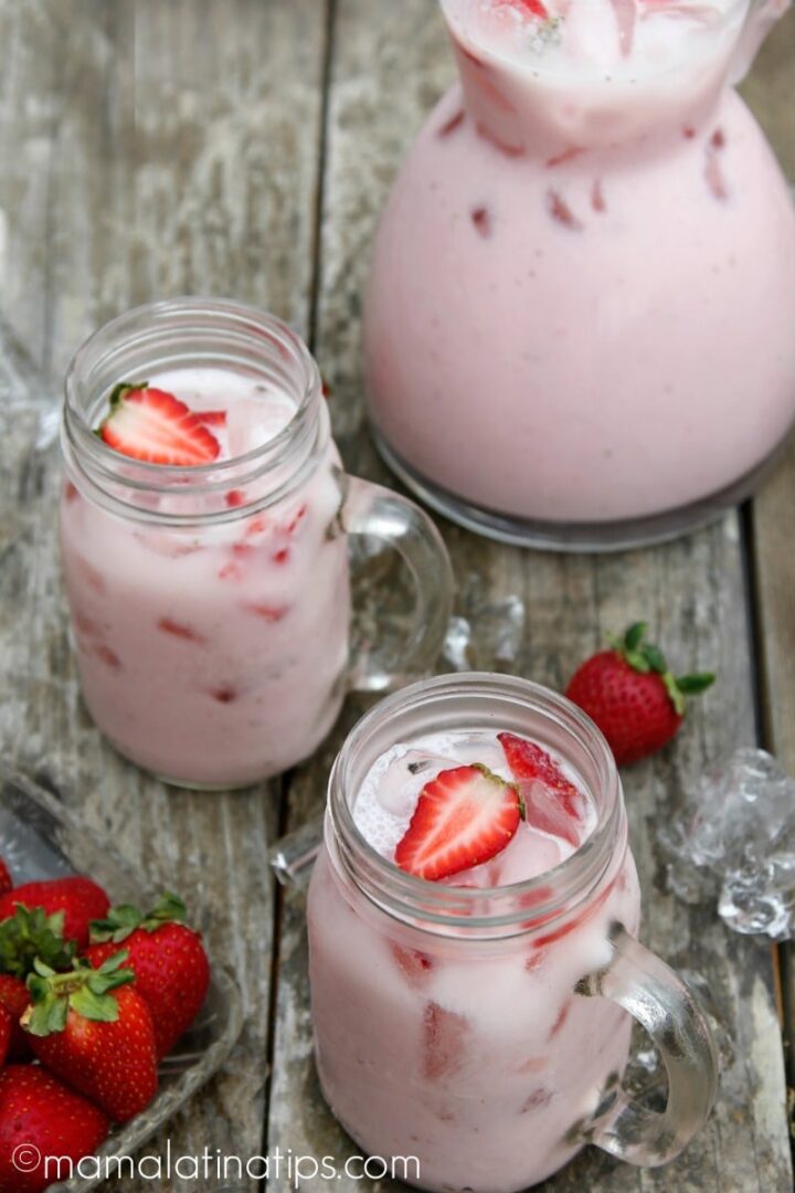 Image of two mason jars and a jug filled with strawberry horchata.