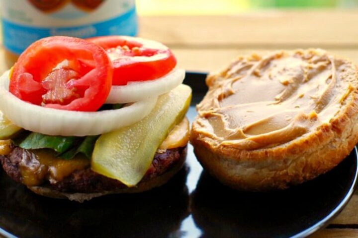 Image of open burger showing spread of peanut butter on one half of the bun.