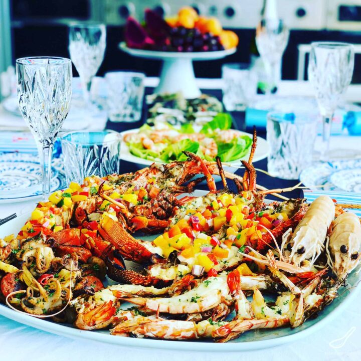 Image of platter of grilled lobsters on table setting.