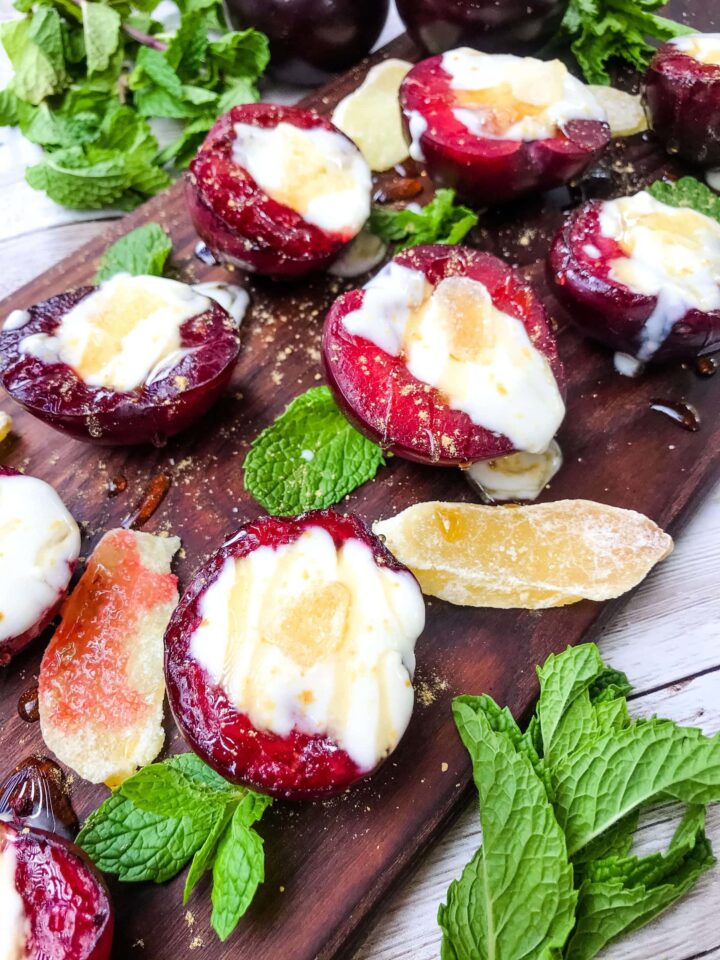 Image of grilled halved plums filled with ginger honey yogurt.