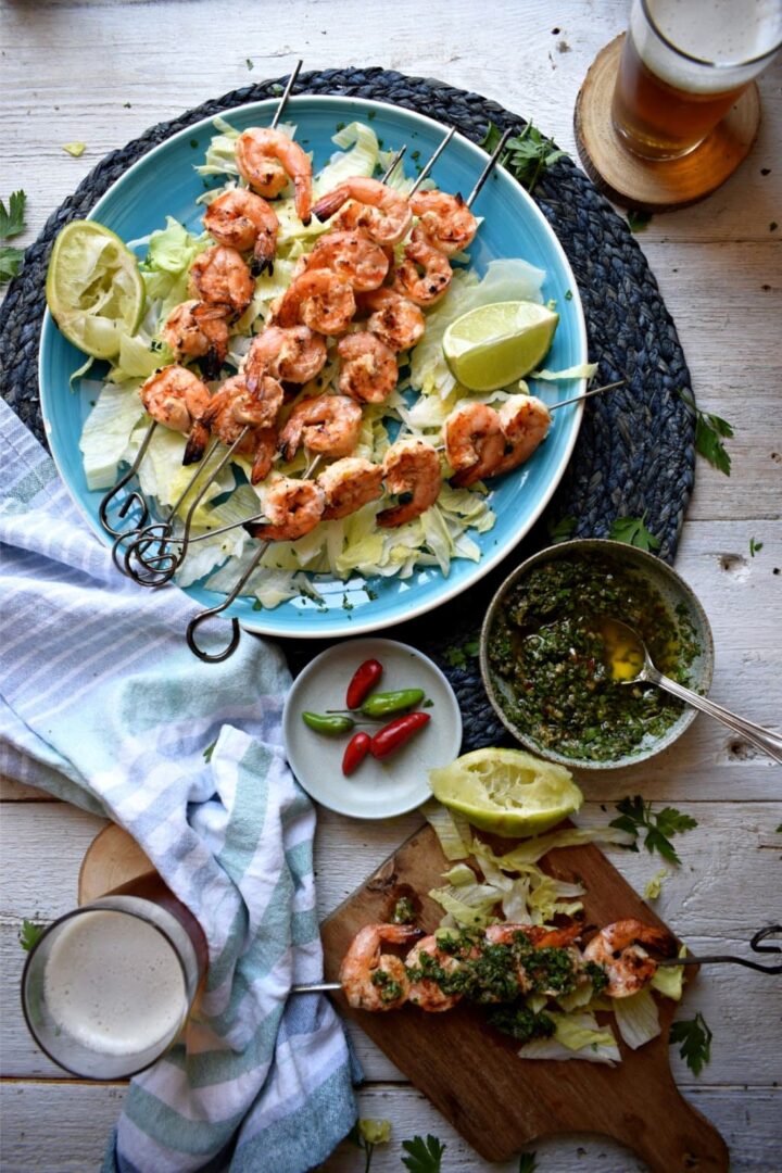 Image of plate of grilled shrimps with bowl of chimichurri.