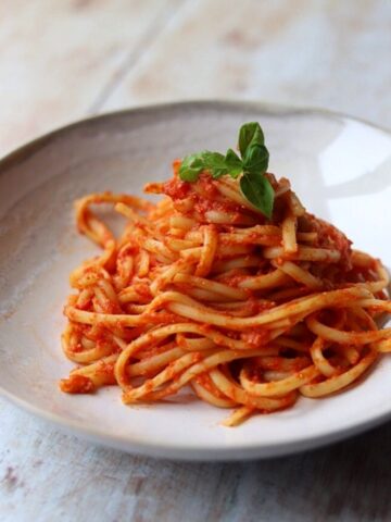 Image of Linguine with tomato sauce and fresh basil in white bowl