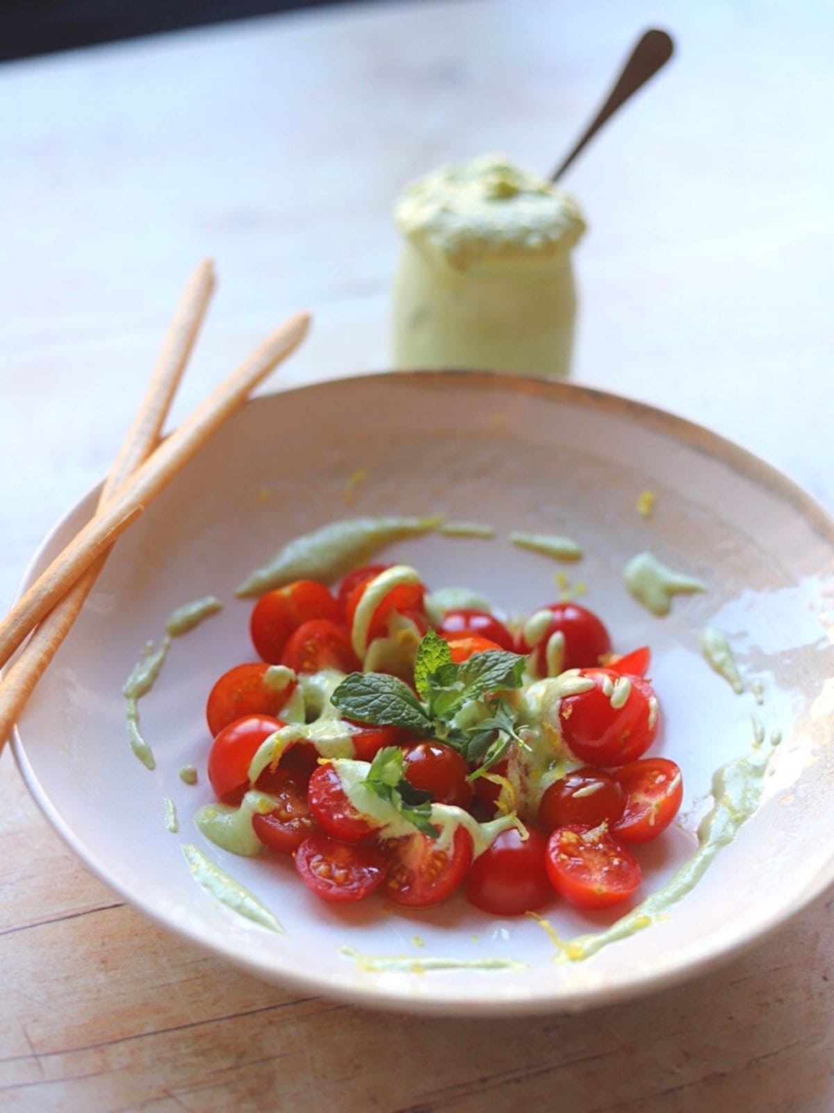 Bowl with feta dressing on cherry tomatoes.