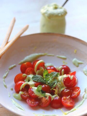 whipped feta dip over halved cherry tomatoes in a bowl