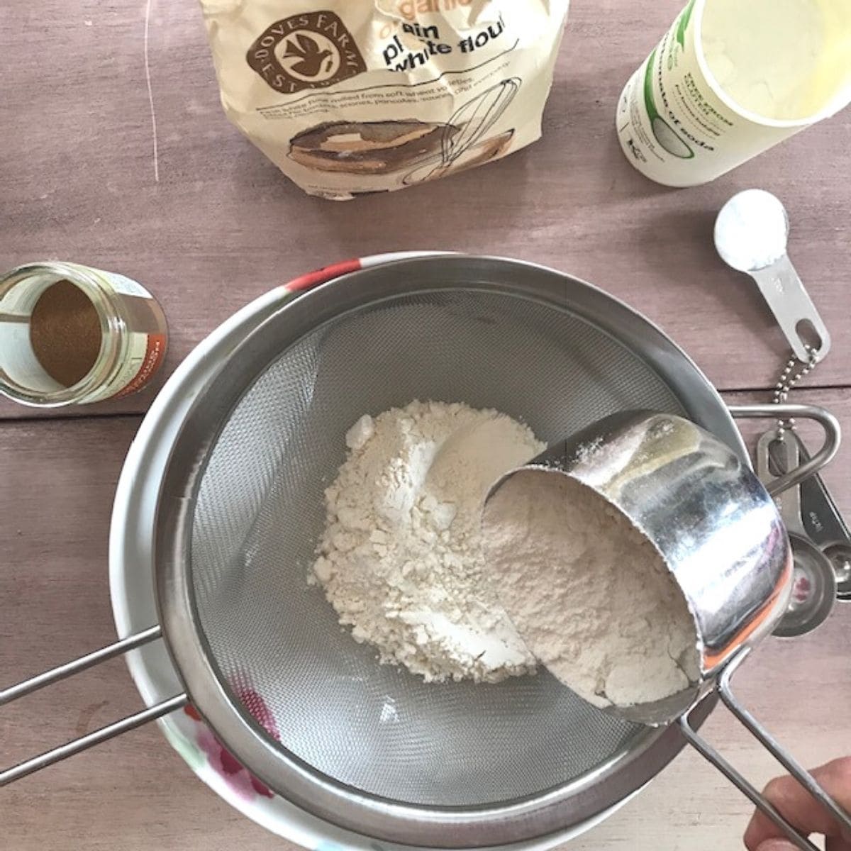 Pouring flour into metal sieve and  bowl.