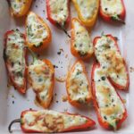 Close up of stuffed peppers in roasting dish after cooking.