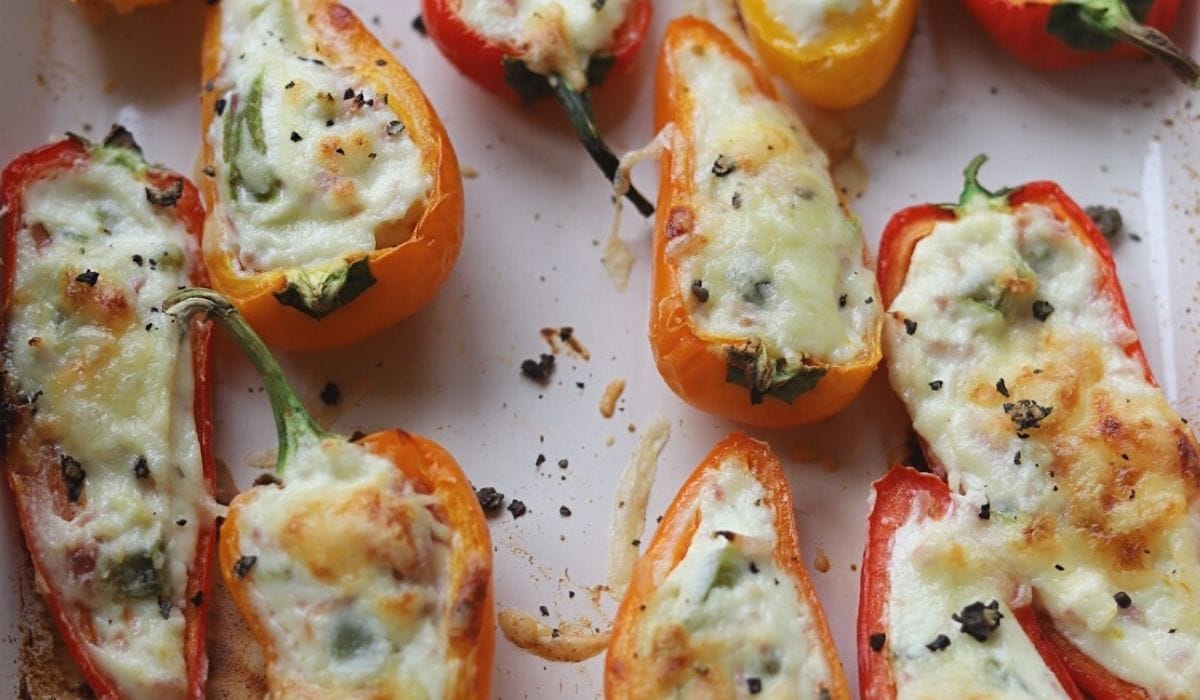 Roasted stuffed peppers in an enamel baking dish.