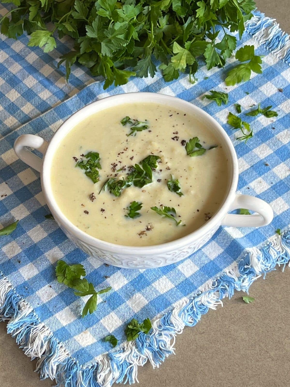 Cullen skink soup in white bowl with fresh parsley garnish.