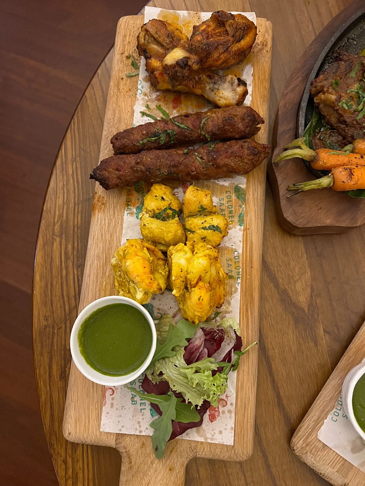 Variety of non veg kebabs on wooden platter.