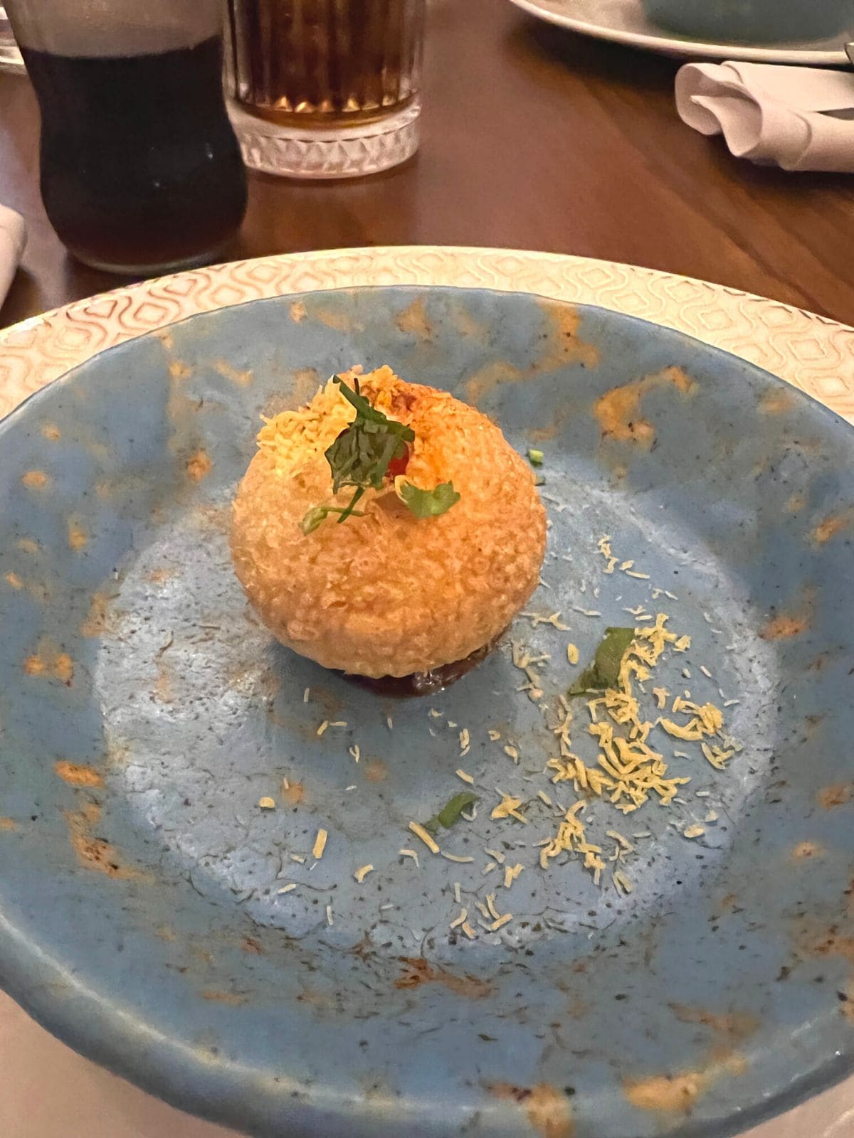 Pani puri starter on small blue plate.