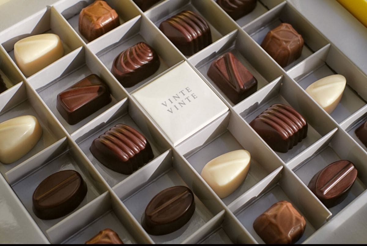 Assorted chocolates in white box.