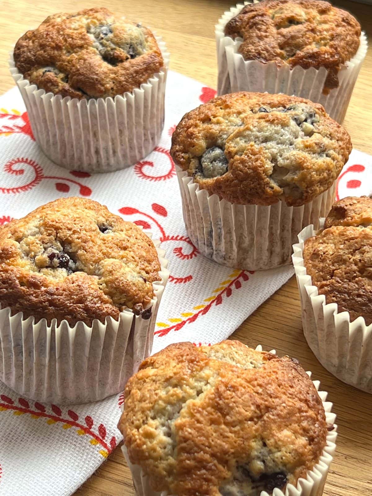 Cherry muffins on a printed teatowel.