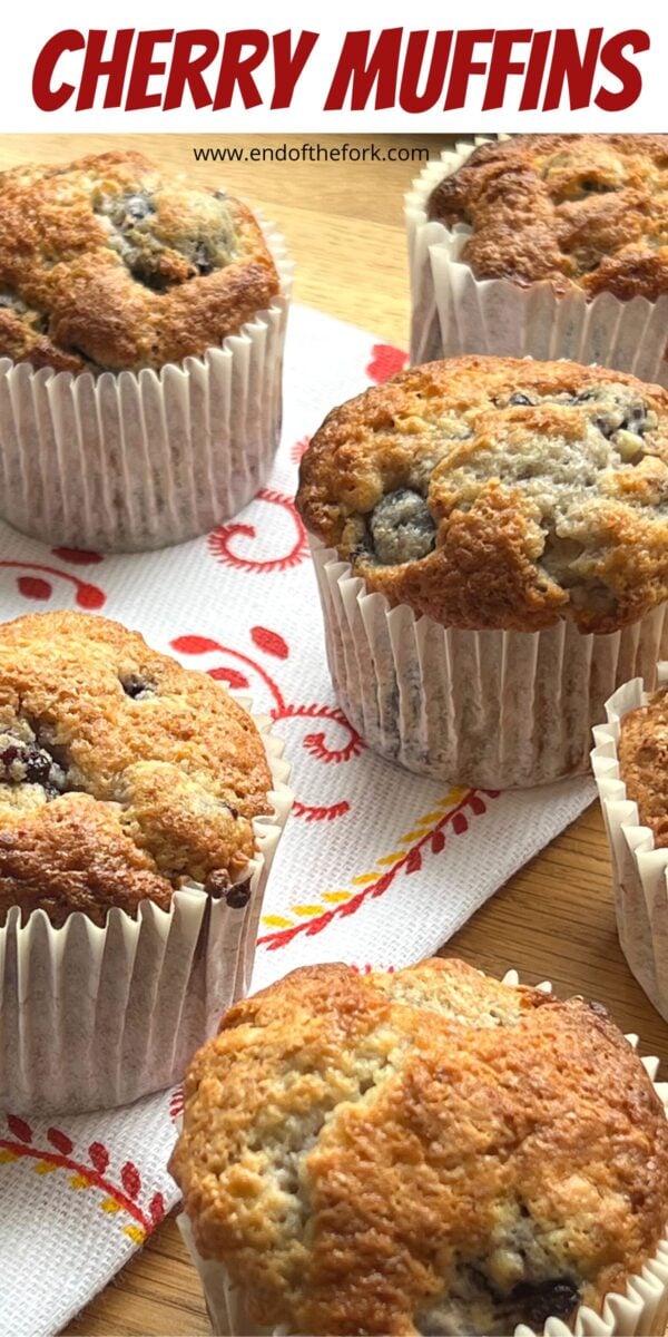 Pin image of several cherry muffins on printed tea towel.