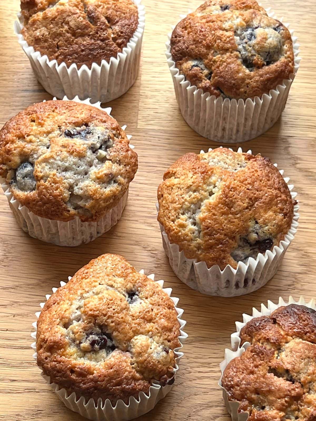 Cherry muffins on a wooden counter.