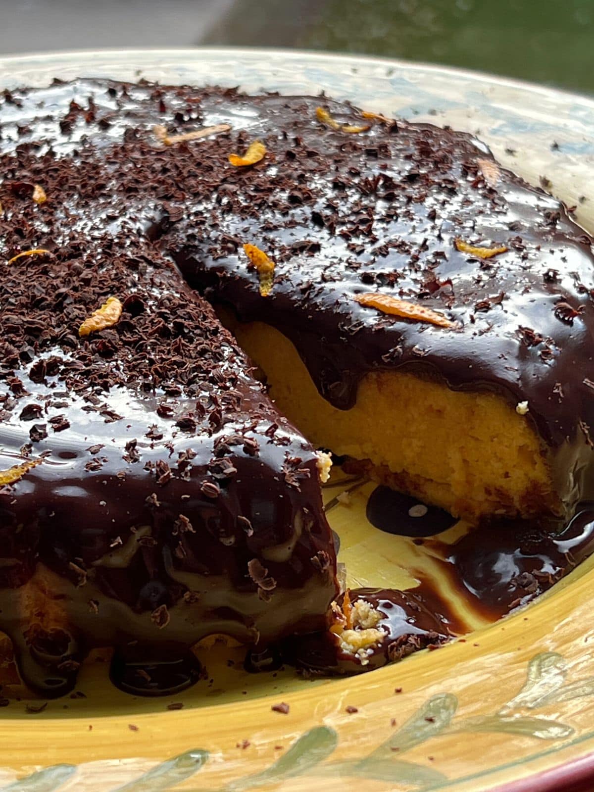 Sliced chocolate orange cake on yellow plate.