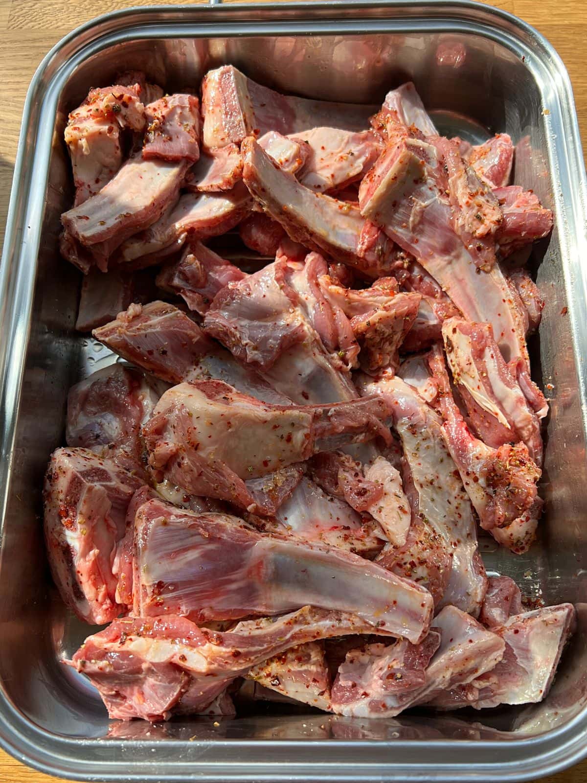 Marinated lamb ribs in a roasting dish.