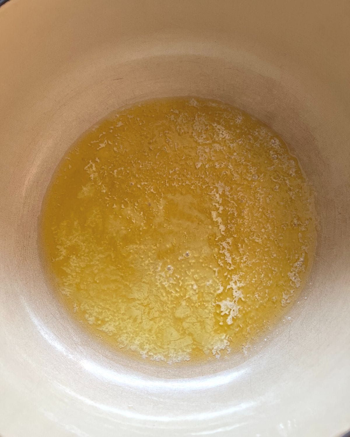 Overhead view of melted butter in saucepan.
