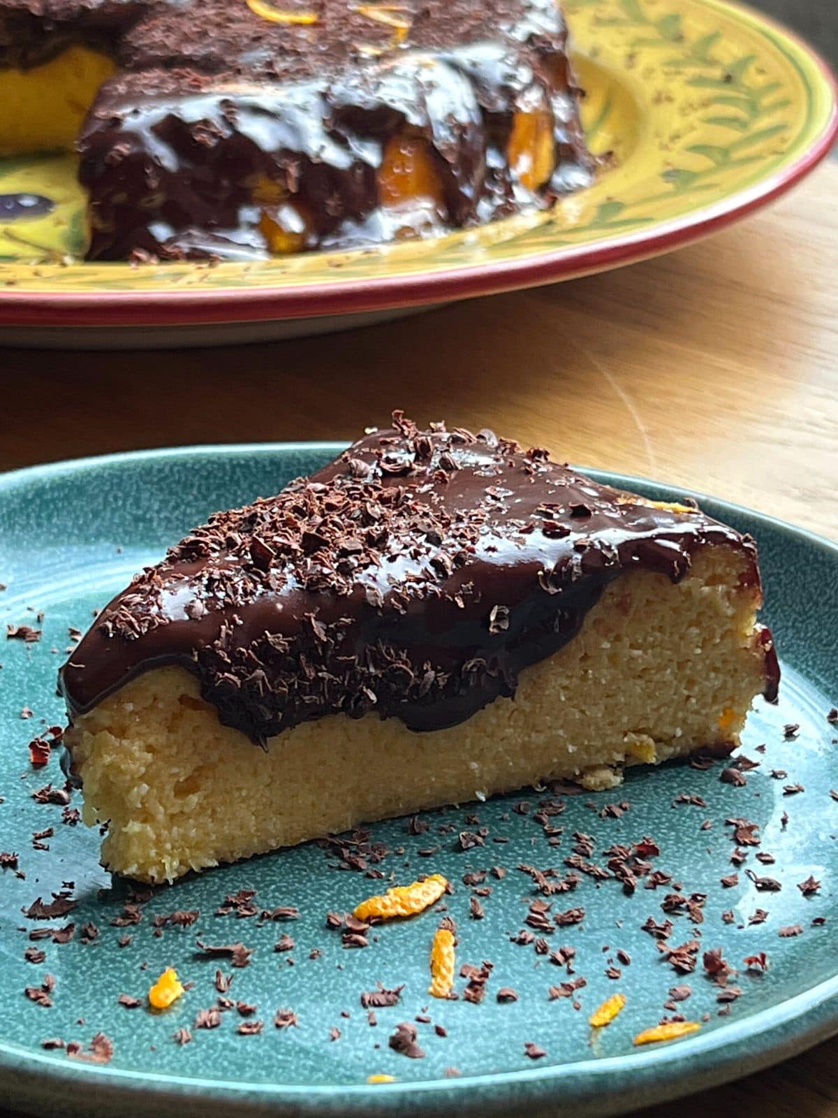 Slice of chocolate orange cake on a green plate.