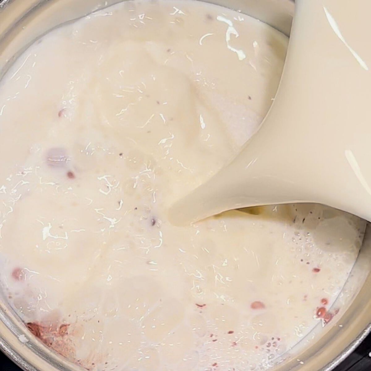 Milk poured into ingredients in small saucepan.