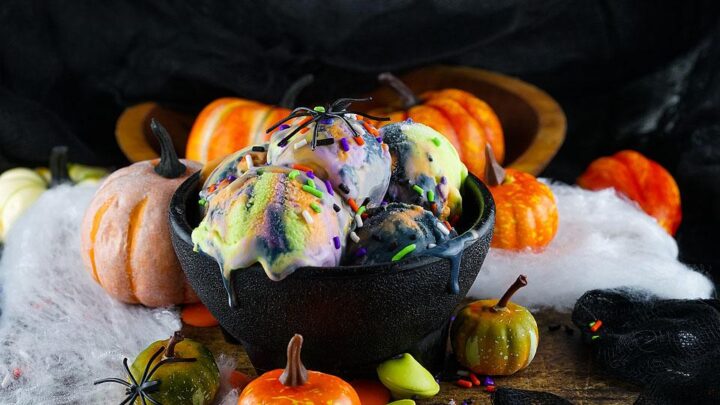 Multicoloured ice cream in a black bowl.
