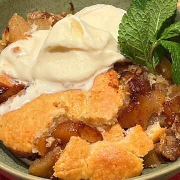 Close up of pear cobbler with scoop of vanilla ice cream.