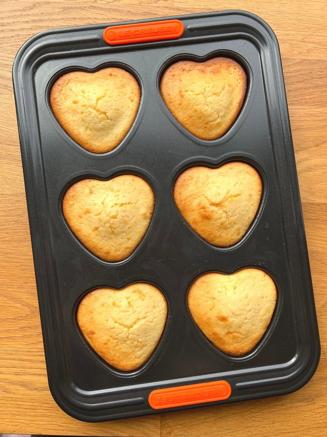 Golden freshly baked mini cakes cooling in the baking tray.
