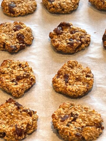 Banana and date oat cookies on a lined baking sheet.