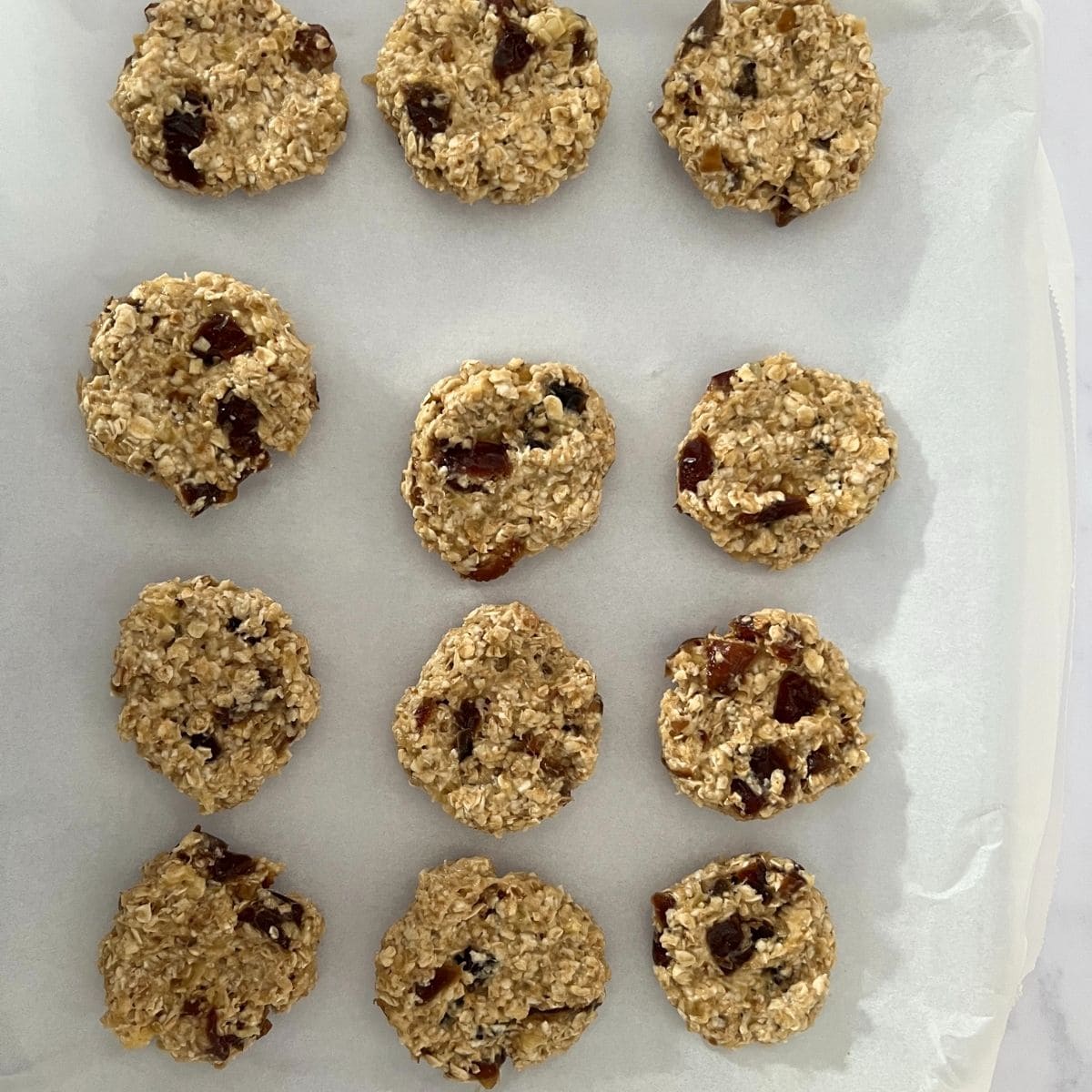 Pressed cookies on lined baking sheet.